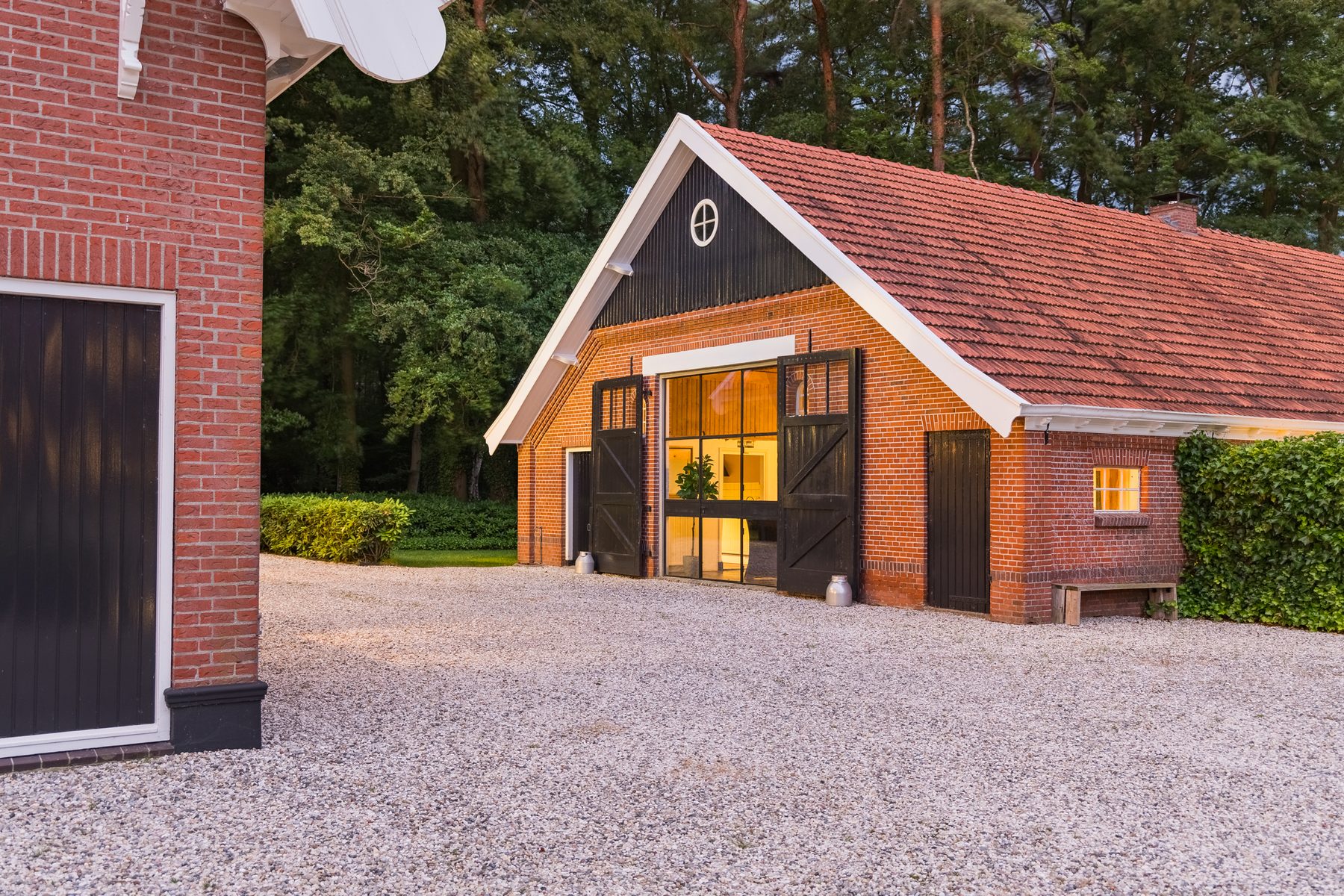 De woonboerderij bij avond, met verlichte ramen