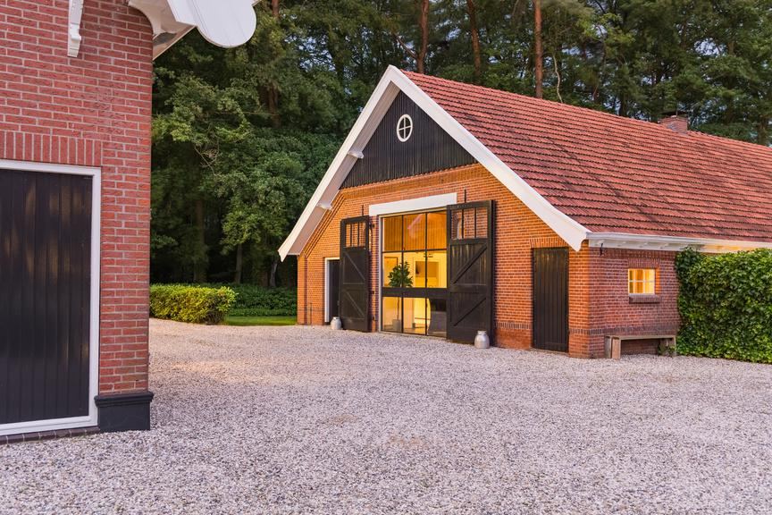 De woonboerderij bij avond, met verlichte deel