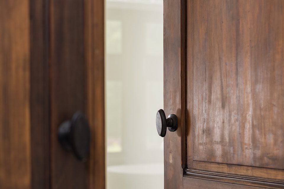 Detail van de massief houten paneeldeuren met zwarte knop