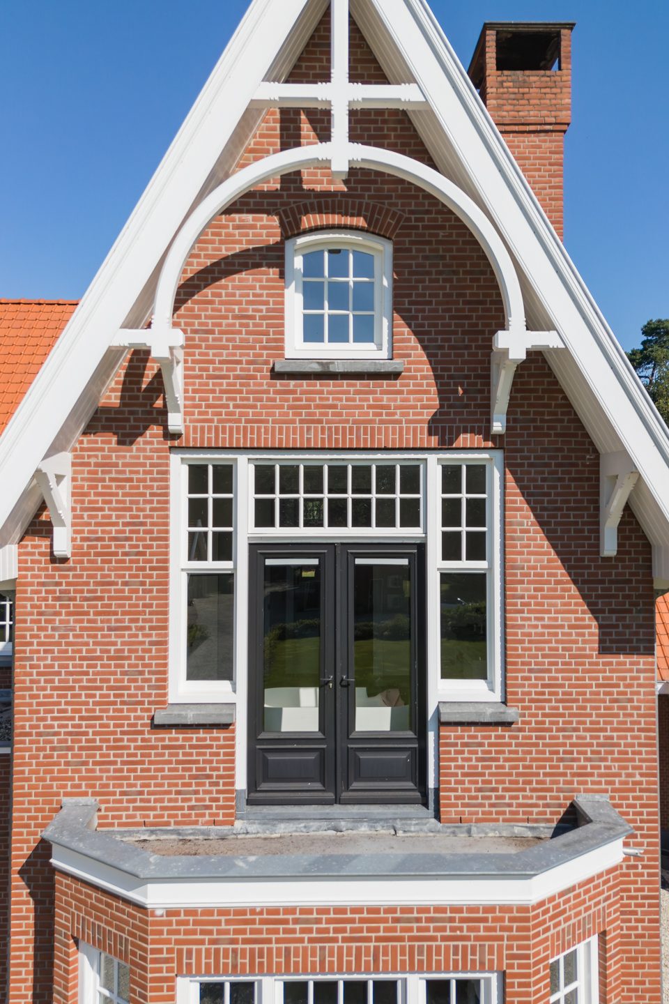 Detail van de topgevel met metselwerk en houten windveren