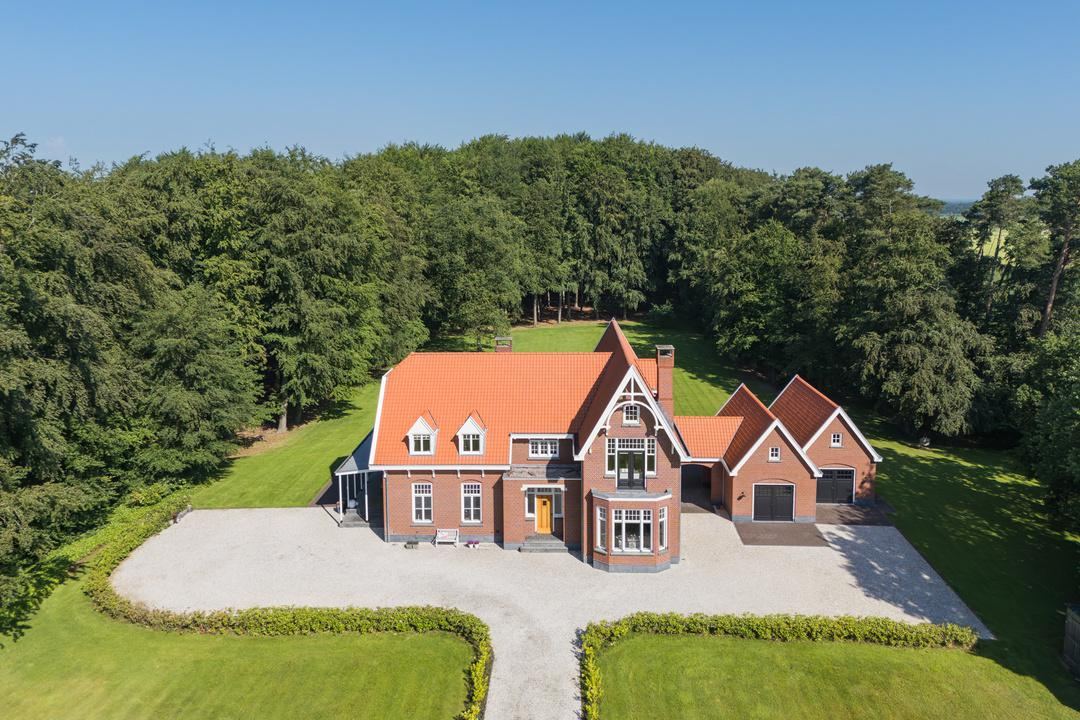 Luchtfoto van het landhuis en de bijgebouwen in het Twentse coulisselandschap