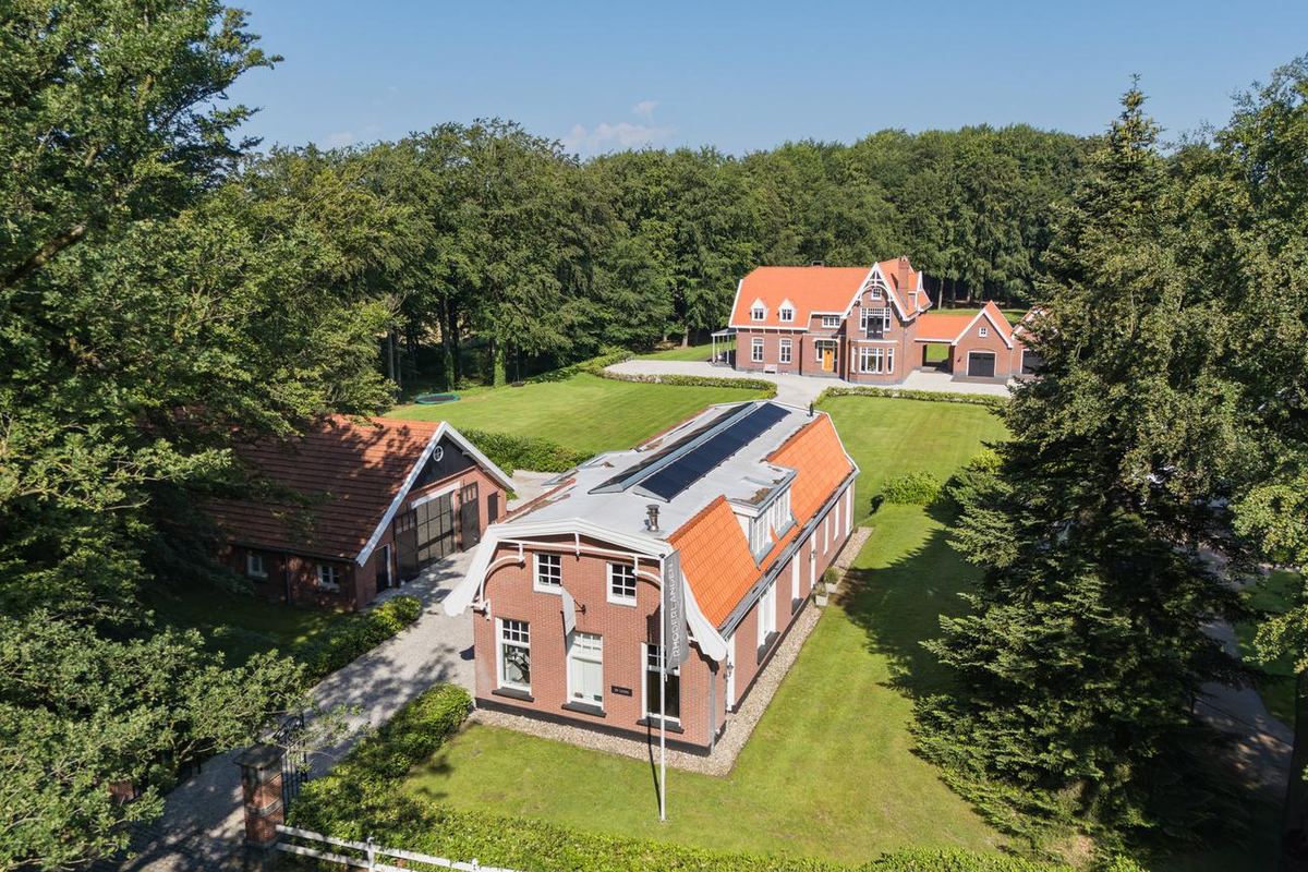 Luchtfoto van het landgoed met bos, gazons en gebouwen